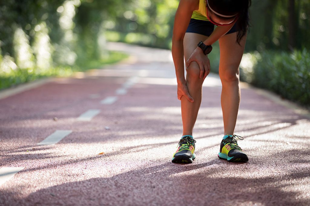 Female runner suffering with pain on sports running knee injury