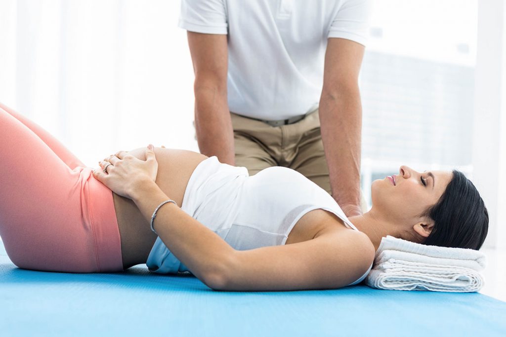 Chiropractor examining to pregnant woman